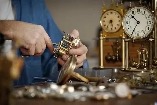 A designer's hands assembling a clock.